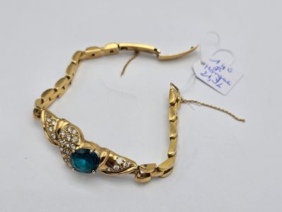 une photo d'un bracelet en or orné de pierres bleues