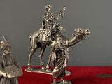 a statue of a man riding a camel next to a statue of a man on a camel