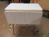 a small white table with a wooden top on a tile floor
