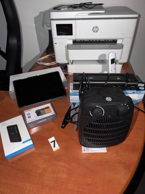 une imprimante et d'autres appareils électroniques posés sur un bureau à côté d'un ordinateur portable