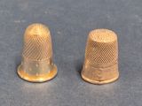pair of thimbles on a table with a blue background