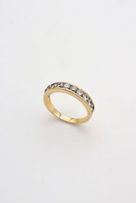 a gold ring with black and white diamonds on a white background
