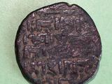 an old coin with writing on it on a green surface