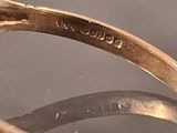 a gold ring with a diamond on it sitting on a table