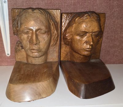two wooden sculptures of a man and a woman on a shelf