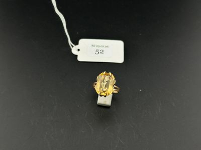 a close up of a gold ring on a black surface with a price tag