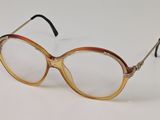 une paire de lunettes posée sur une surface blanche, sur fond blanc