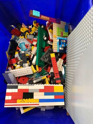 un bac bleu rempli de Lego et d'autres jouets