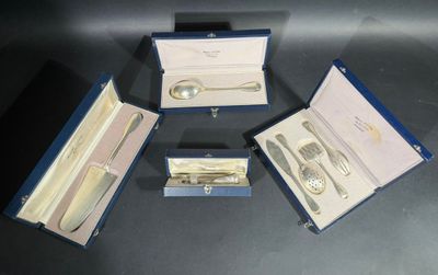 trois pièces d'argenterie dans un coffret bleu posé sur une table