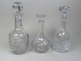 three clear glass bottles sitting next to each other on a white surface