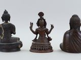 three bronze statues of buddhas sitting on top of a table