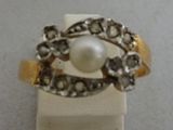 a ring with a pearl in it sitting on a stand
