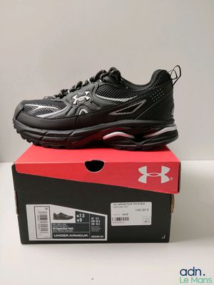 une paire de baskets noires posée sur une boîte rouge