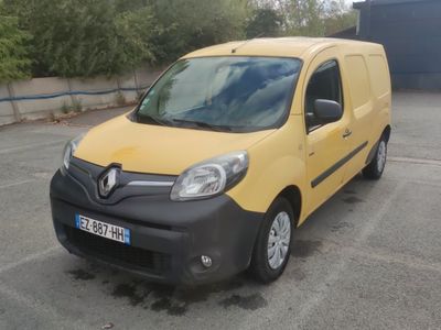 une camionnette jaune et noire garée sur un parking, avec des arbres en arrière-plan