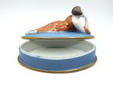 a figurine of a woman laying on top of a plate