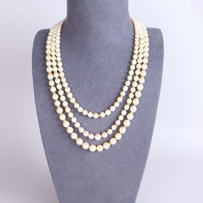 a three strand pearl necklace on a mannequin display