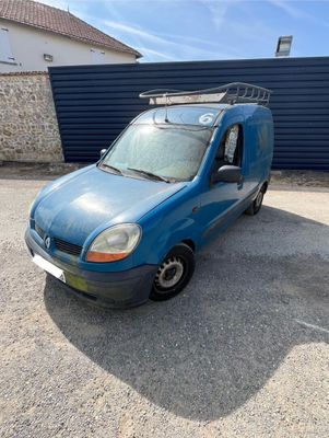 a blue van parked in front of a building with a roof rack