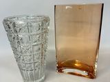 two glass vases sitting next to each other on a white surface