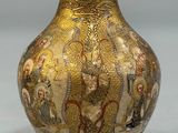 a gold vase with a picture of a dragon on it