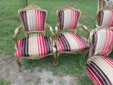 four chairs with striped upholstered cushions sit in the grass