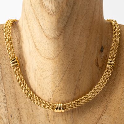 un gros plan sur un mannequin portant un collier à chaîne en or