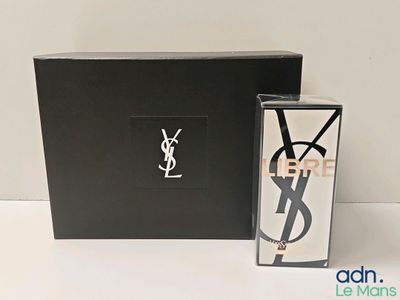 Eau de toilette Yves Saint Laurent en vaporisateur, dans un coffret noir, à côté d'un autre coffret noir orné d'un logo YSL blanc