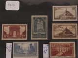 Plusieurs timbres différents sont exposés dans une vitrine posée sur une table.