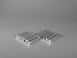 four pieces of silver metal are arranged on a white surface