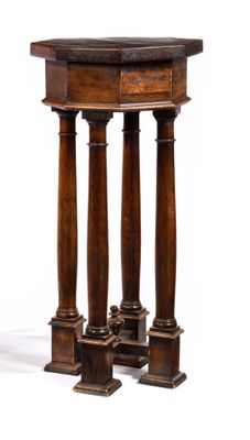 a small wooden table with three pillars on it