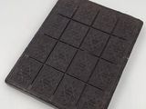 dark chocolate bar on a white surface with a pattern of hearts