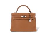 un sac à main en cuir marron muni d'un fermoir métallique sur la poignée
