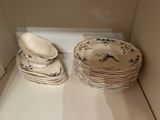 many plates and bowls sitting on a shelf in a room