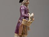 a figurine of a man with a basket of fruit