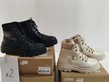 two pairs of black and white shoes sitting on top of boxes
