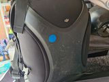 a person holding a black bag with a blue dot on it