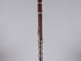 a close up of a wooden flute on a clear stand