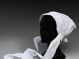 une tête de mannequin noire coiffée d'un bonnet blanc