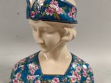 a figurine of a woman with a hat on her head