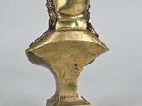 an image of a gold statue of a man with a hat on top of a bust
