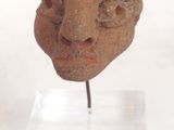an image of a sculpture of a face on a stand