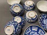 several blue and white porcelain dishes and bowls on a table