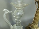 a glass vase with a gold handle next to a glass vase with a gold handle