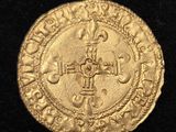 Gros plan sur une pièce d'or ornée d'une croix