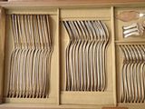 many forks and spoons in a wooden box