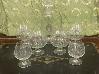 six verres à vin et une carafe posés sur une table