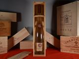 une bouteille de vin dans un coffret en bois, à côté d'autres coffrets