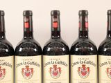 four bottles of red wine are lined up on a table