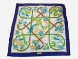 a close up of a blue and green scarf with birds and flowers