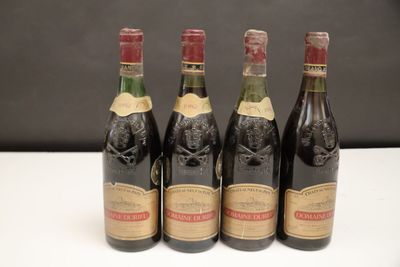 quatre bouteilles de vin sont alignées sur une table