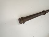 a metal pole with a wooden handle hanging on a wall